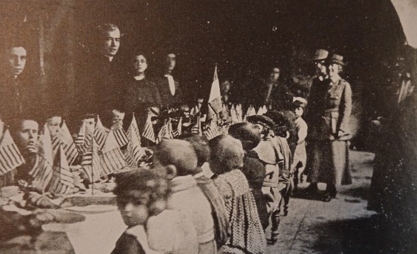 Pranzo del Natale 1918 degli orfani di guerra al Ricreatorio Popolare Pio II a Siena. Si notano bandierine degli Stati Uniti d’America (<i>Siena dei nonni</i>, volume I, Monteriggioni, Banca di Credito Cooperativo, 1994)